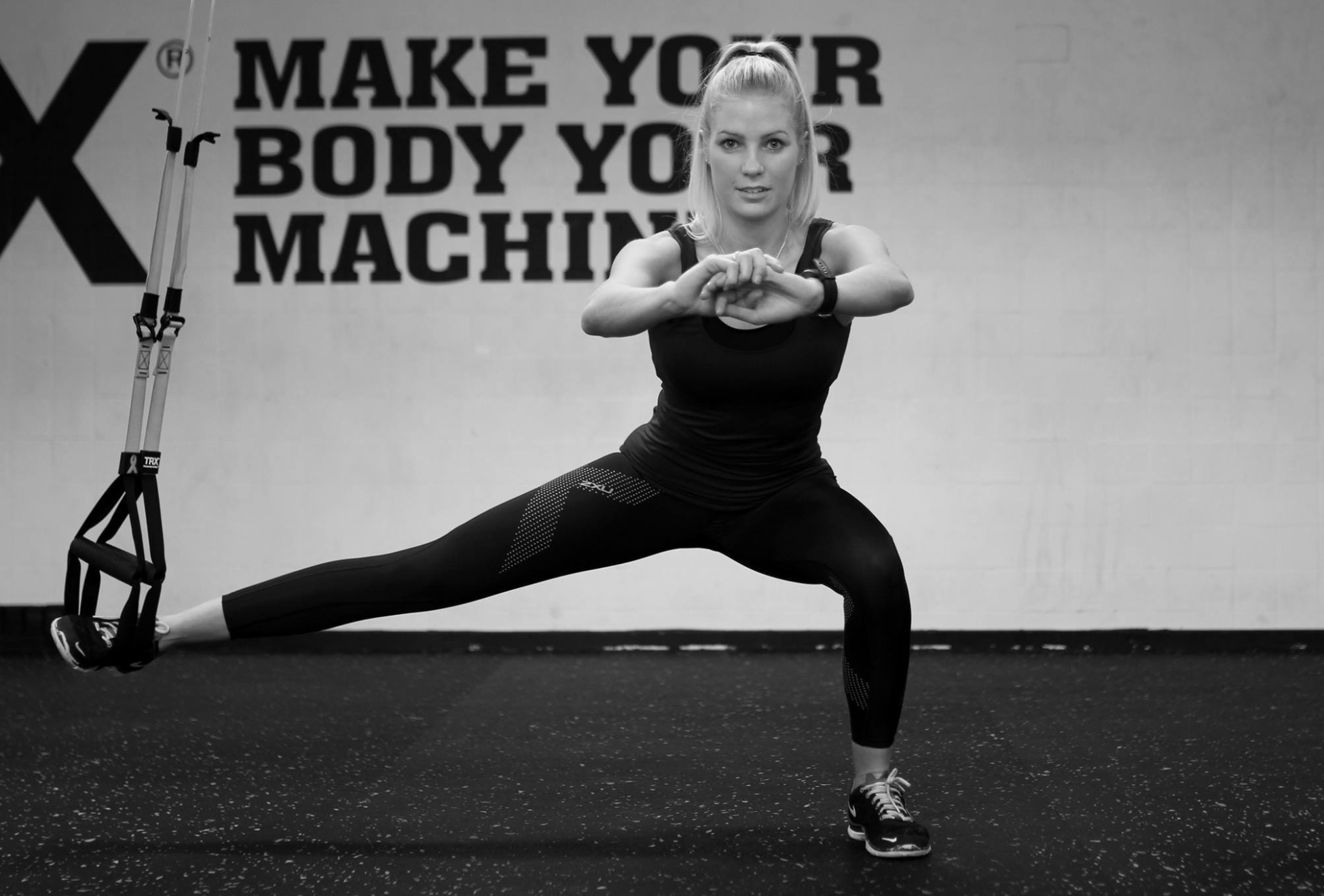Anja Lambek i bevægelse foran TRX-væggen 'Make your body your machine' i ACTGYM-studiet.